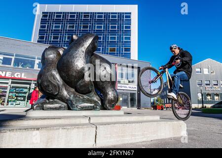 Junger Mann auf dem Fahrrad in der Innenstadt von Nuuk oder Godthåb, der Hauptstadt und der größten Stadt Grönlands. Stockfoto