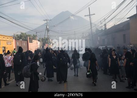 Weihrauch füllt die Straßen, während die Menschen während der Karwoche an einer Semana Santa Prozession in Antigua, Guatemala, einer historischen Kolonialstadt, teilnehmen. Stockfoto