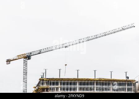 Industrieturmkran baut neue Beton-Stadtgebäude oder Wohnungen auf der Baustelle. Stockfoto