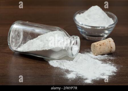 Backpulver - Natriumbicarbonat in einem Glas auf dunklem Holzhintergrund. Stockfoto
