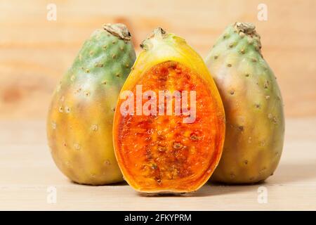 Kaktusfrüchte mit Kaktus aus Kaktus - Opuntia ficus indica; Foto auf Holzhintergrund. Stockfoto