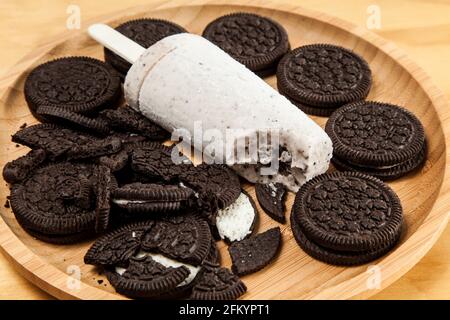 Eis - leckere und erfrischende Kekse und Creme mit Popsicle-Geschmack, Foto auf Holzhintergrund. Stockfoto