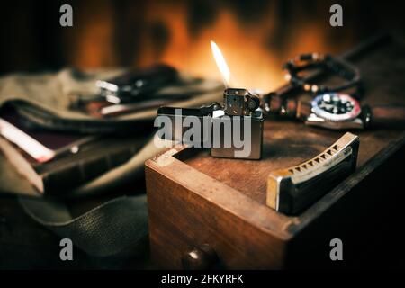 Gebürstetes Chrom-Feuerzeug mit winddichtem Brennen im Dunkeln. Stockfoto