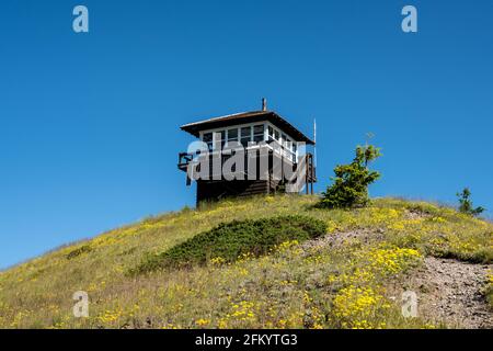 Huckleberry Lookout Tower auf dem Gipfel des Gipfels mit blauem Himmel Stockfoto