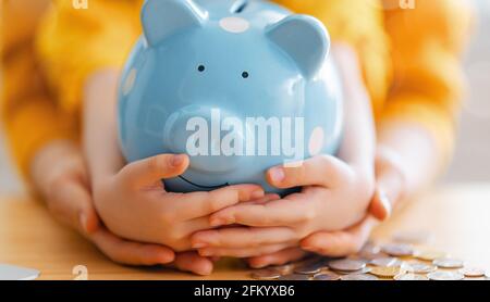 Frau und Kind mit einem Sparschwein. Konzept der Berechnung der Ausgaben, Verwaltung des Familienbudgets. Stockfoto