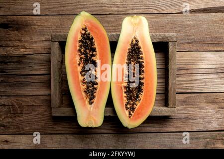 Frische tropische Papaya-Früchte in einem Holzlieferkarton Ein hölzerner Hintergrund flach Lay Draufsicht mit Kopierraum Für einige Werbetexte Stockfoto