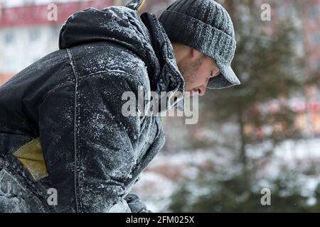 Nahaufnahme eines Montagearbeiters mit schwarzer Wintermütze am Arbeitsplatz Stockfoto