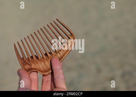 Handgefertigter Holzkamm für Kopfmassage und Haarkämmen. Haarpflegekonzept. Stockfoto