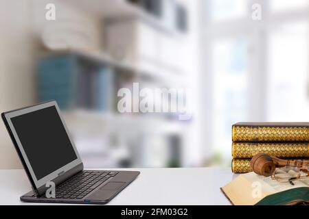 Moderner tragbarer Laptop mit leerem Bildschirm und einem geöffneten alten Buch mit einer Brille und einer Tabakpfeife auf ihnen über verschwommenem Büro. Die Lehrer da Stockfoto