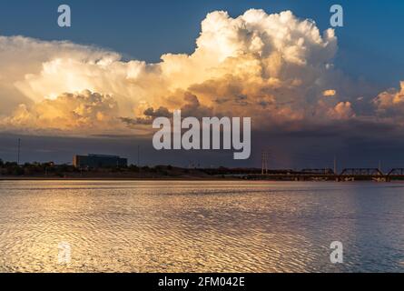 Wunderschönes Gewitter bei Sonnenuntergang, das sich auf einem See spiegelt Stockfoto