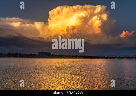 Wunderschönes Gewitter bei Sonnenuntergang, das sich auf einem See spiegelt Stockfoto