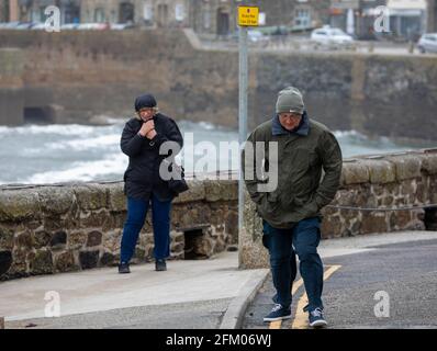 Die Menschen kämpfen gegen die starken Winde in Porthleven, Cornwall, Großbritannien Stockfoto