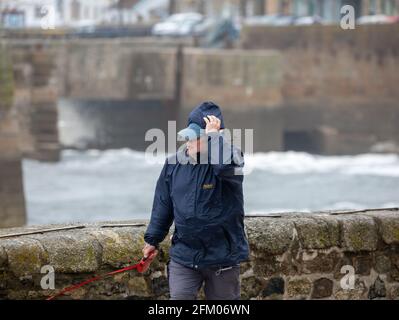 Die Menschen kämpfen gegen die starken Winde in Porthleven, Cornwall, Großbritannien Stockfoto