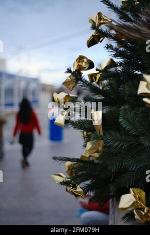 Eine asiatisch-philippinische Frau geht an einem Weihnachtsbaum in Palavas les Flots in der Nähe von Carnon Plage und Montpellier, in der Region von okzitanie, Südfrankreich, vorbei Stockfoto