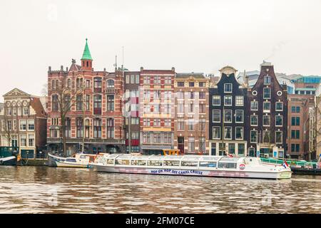 Bootstour entlang des Kanals mit bunten Häusern am Flussufer, Amsterdam, Nordholland, Niederlande Stockfoto