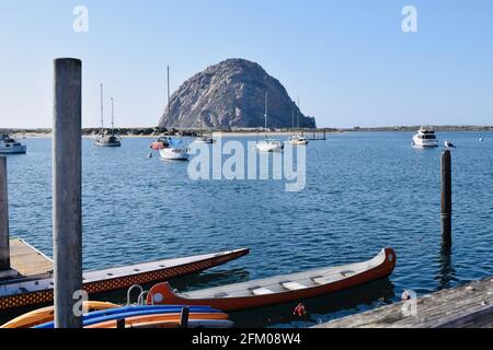 Schöne Aufnahme von Booten auf einem Hafen mit der Morro Bay Rock in der Ferne Stockfoto