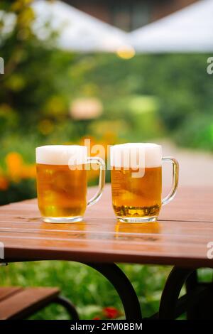 Auf dem Tisch in einem Café befinden sich Glaskrüge mit Bier Terrasse Stockfoto