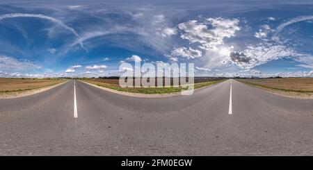 Vollständiges, kugelförmiges, nahtloses Panorama 360 Grad-Ansicht bei No Verkehr alte Asphaltstraße zwischen Feldern mit klarem Himmel und Weiße Wolken in gleicheckig Stockfoto