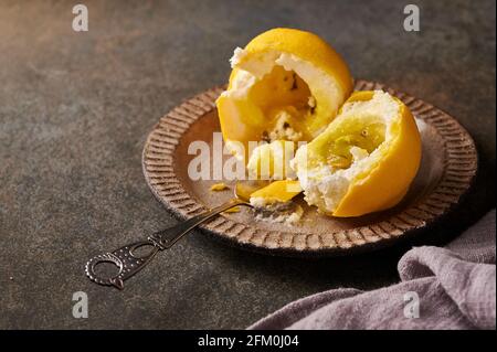 Original Dessert Obst Zitrone nach der Idee der französischen Konditoren in der Hälfte gebrochen - Creme auf der Basis von cremigem Mascarpone mit Zitrone in Schale von Schokolade Velours. Selektiver Fokus Stockfoto