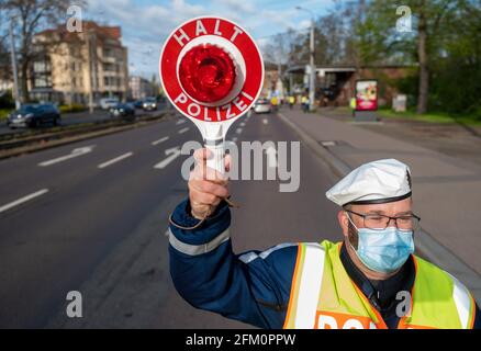 Leipzig, Deutschland. Mai 2021. Ein Polizeibeamter der Leipziger Verkehrspolizei hält einen Autofahrer in der Jahnallee in Leipzig an. Die Kontrollen führt die Leipziger Polizei im Rahmen der bundesübergreifenden Verkehrssicherheitskampagne sicher.mobil.leben durch. Ziel ist es, die Straßenverkehrssicherheit für alle Verkehrsträger zu erhöhen, die am Straßenverkehr beteiligt sind. Quelle: Hendrik Schmidt/dpa-Zentralbild/ZB/dpa/Alamy Live News Stockfoto