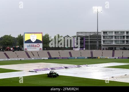 Die Abdeckungen befinden sich auf dem Spielfeld und die Flutlichter sind eingeschaltet, wenn während des Hampshire vs Essex Eagles, Vitality Blast T20 Cricket am Ageas B, starker Regen fällt Stockfoto