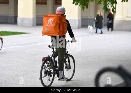 München, Deutschland. Mai 2021. Topic picture Coronavirus pandemic: Delivery Services sind die Nutznießer der Coronavirus-Pandemie. Ein Fahrer, ein Radfahrer vom Lieferando-Lieferservice, fährt mit seinem Fahrrad durch München und liefert Lebensmittel. Credit: dpa/Alamy Live News Stockfoto