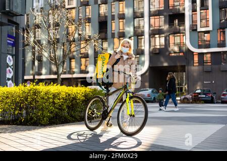 KIEW, UKRAINE - 28. April 2021: Glovo-Fahrradkurier auf der Straße. Lieferung von Glovo Lieferservice Stockfoto