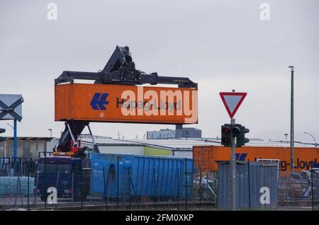 Bamberg, Deutschland - 6.4.2021. Ein orangefarbener Hapag-Lloyd-Container wird auf einen LKW verladen Stockfoto