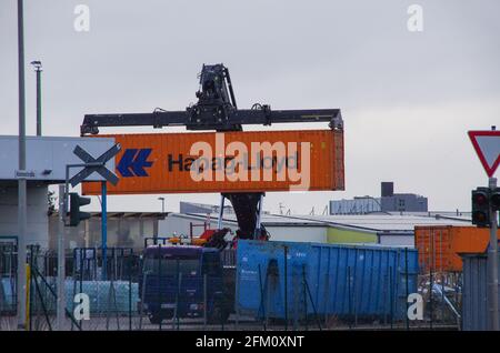 Bamberg, Deutschland - 6.4.2021. Ein orangefarbener Hapag-Lloyd-Container wird auf einen LKW verladen Stockfoto