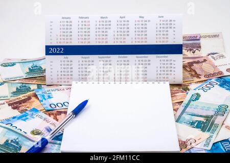 Papiergeld und Kalender 2022. Schwarzer Stift und Notizblock. Russisches Geld und ein Notizbuch. Stockfoto