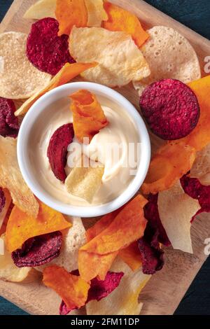 Bunte Gemüsechips mit einem hausgemachten Dip aus nächster Nähe Stockfoto