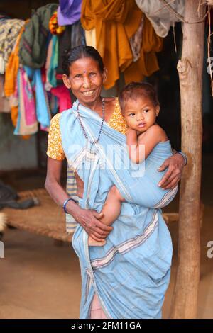 Großmutter trägt ihren Enkel im Dorf Masaguda, Bezirk Srikakulam, Andhra Pradesh, Indien. SAVARA-STAMM Stockfoto