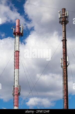 Hohe Rohre, auf denen die Ausrüstung für die Mobilfunkkommunikation installiert ist. Mobile Antenne. Funkturm. Alt und neu Stockfoto