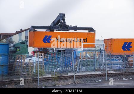 Bamberg, Deutschland - 6.4.2021. Ein orangefarbener Hapag-Lloyd-Container wird auf einen LKW verladen Stockfoto