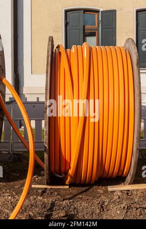 Orangefarbenes Telefonkabel auf EINER großen Holzrolle, Datenkabel wird unterlegt Stockfoto