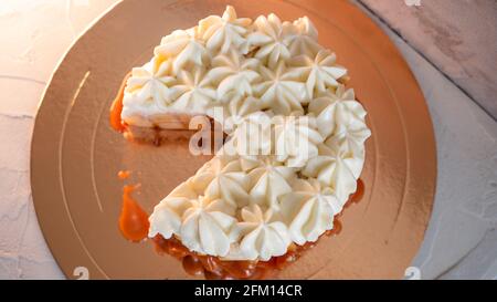 Banoffi-Kuchen. Kuchen ohne Backen auf Shortbread-Teig. Frisch geschnittene Bananen in hausgemachtem Karamell, Schlagsahne darauf, Garvorgang, flach legen. Stockfoto
