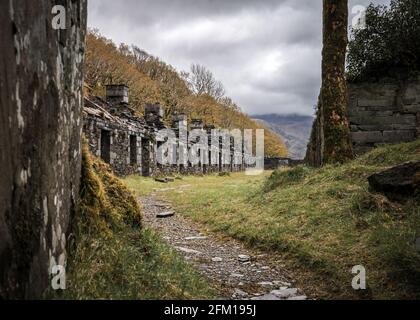 Reihe verlassene alte Bergarbeiterhütten im Schieferminenbruch Dinorwic North Wales. Unheimliche, veraltete Kasernen, die auf der Bergspitze aus dem alten Bergbau zurückgelassen wurden Stockfoto