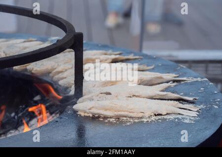 Prozess des Kochens europäischen gerochen Fisch in Mehl auf schwarz Beim Food Festival Stockfoto