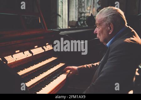 Der alte Mann spielt in der Kirche die Orgel Stockfoto