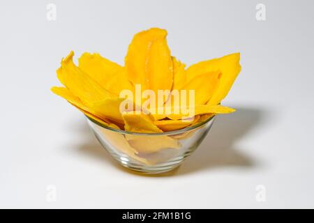 Getrocknete Mangoscheiben in Glasschüssel isoliert auf weißem Hintergrund Stockfoto