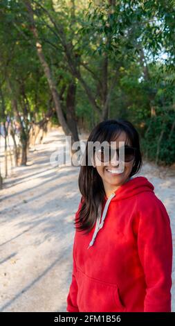 Porträt einer jungen Frau in einer grünen Sonnenbrille park bei Sonnenuntergang Stockfoto