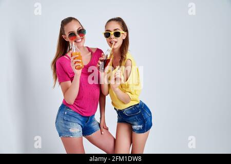 Nahaufnahme Porträt von zwei Person schön niedlich cool faszinierend schön Attraktive charmante fröhliche Mädchen in legerer Kleidung mit Getränk isoliert Vorbei Stockfoto