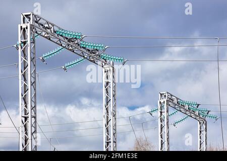 Zwei elektrische Hochspannungsübertragung H-Rahmen-Türme Masten Einzelschaltung drei Phasen durch Isolatoren über bewölktem stürmischen dunklen Himmel unterstützt. Stockfoto