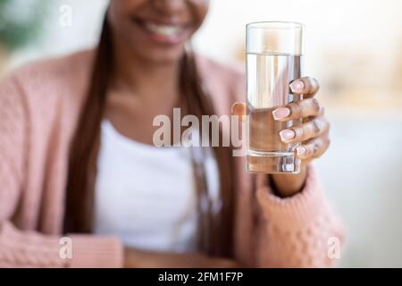 Unverkennbare Schwarze Frau, Die Der Kamera Ein Glas Wasser Anbietet Stockfoto