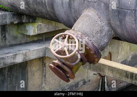 Absperrventil und Rohr über dem Entwässerungskanal für die Regenwasserumleitung von den Stadtstraßen in New Orleans, Louisiana, USA Stockfoto