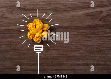 Kreative Idee, Inspiration, Neue Idee und Innovationskonzept mit zerknitterter Papierlampe auf Holzhintergrund Stockfoto