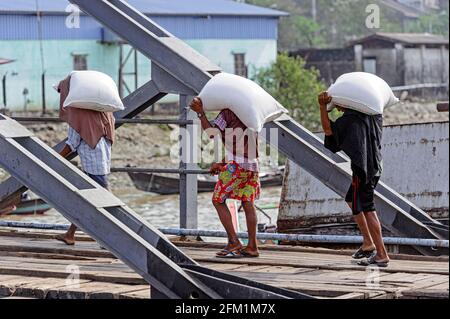 Hafenarbeiter entladen Boote in Yangon Sin auf dem Dam Jetty, Myanmar Birma Stockfoto