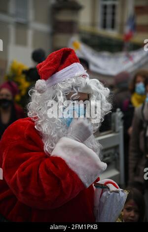 *** KEIN VERKAUF AN FRANZÖSISCHE MEDIEN ODER VERLAGE - RECHTE VORBEHALTEN ***06. Dezember 2020 - Melun, Frankreich: Ein maskierter Weihnachtsmann verteilt Süßigkeiten, während französische Familien gegen den Plan der Regierung protestieren, Eltern zu zwingen, ihre Kinder zur Schule zu bringen. Zwischen 200 und 300 Menschen, darunter mehrere Kinder, marschierten, um ihre Rechte auf "Instruction en Famille" (IEF, Instruction within the family) zu verteidigen. Die französische Regierung will in ihrem Gesetz gegen den "Separatismus", der auf die Bekämpfung des radikalen islam im Land abzielt, die häusliche Schulbildung verbieten. Derzeit ist die Bildung für alle Kinder in Frankreich obligatorisch Stockfoto