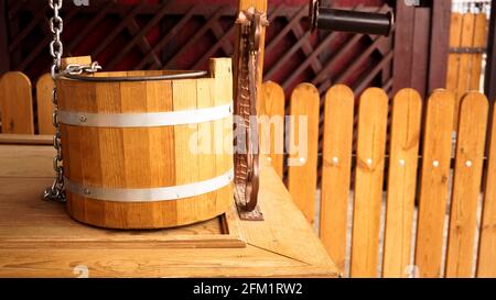 Ländlicher Holzbrunnen. Nahaufnahme eines hölzernen Eimers. Rustikaler Fotostil Stockfoto