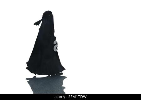 Eine muslimische Frau, die einen Burka und Niqab trägt, gegen den sie isoliert ist Ein weißer Hintergrund, der rechts nach links vom Rahmen läuft Stockfoto